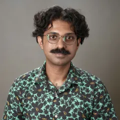 Man with mustache wearing glasses and green floral shirt
