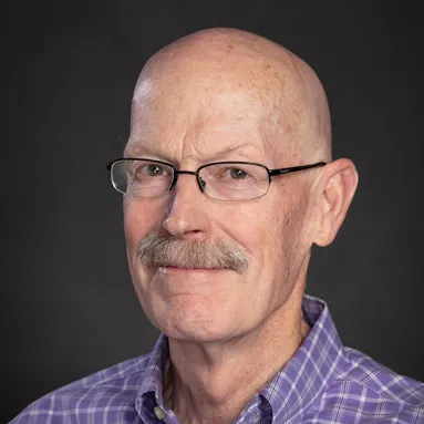 Image of man with glasses wearing a plaid shirt