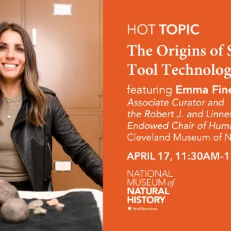 A light-skinned woman with long brown hair, standing behind a table that has what appear to be four large rocks and four small rocks on it. The woman is wearing a black leather jacket, beige tee shirt, and a necklace. There are closed, brown metal cabinets behind her. To the right of the image is a text panel, reading HOT Topic, The Origins of Stone Tool Technology, featuring Emma Finestone, associate curator, Cleveland Museum of Natural History.